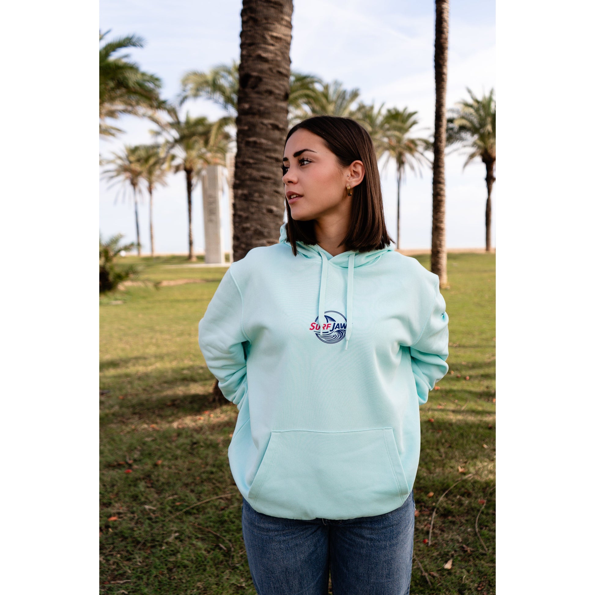 Sudadera SurfJaws de algodón orgánico en tono Ice Mint, ajuste regular. El modelo lleva una talla L, mide 1,56 m y tiene complexión normal, mostrando un estilo cómodo y ecológico