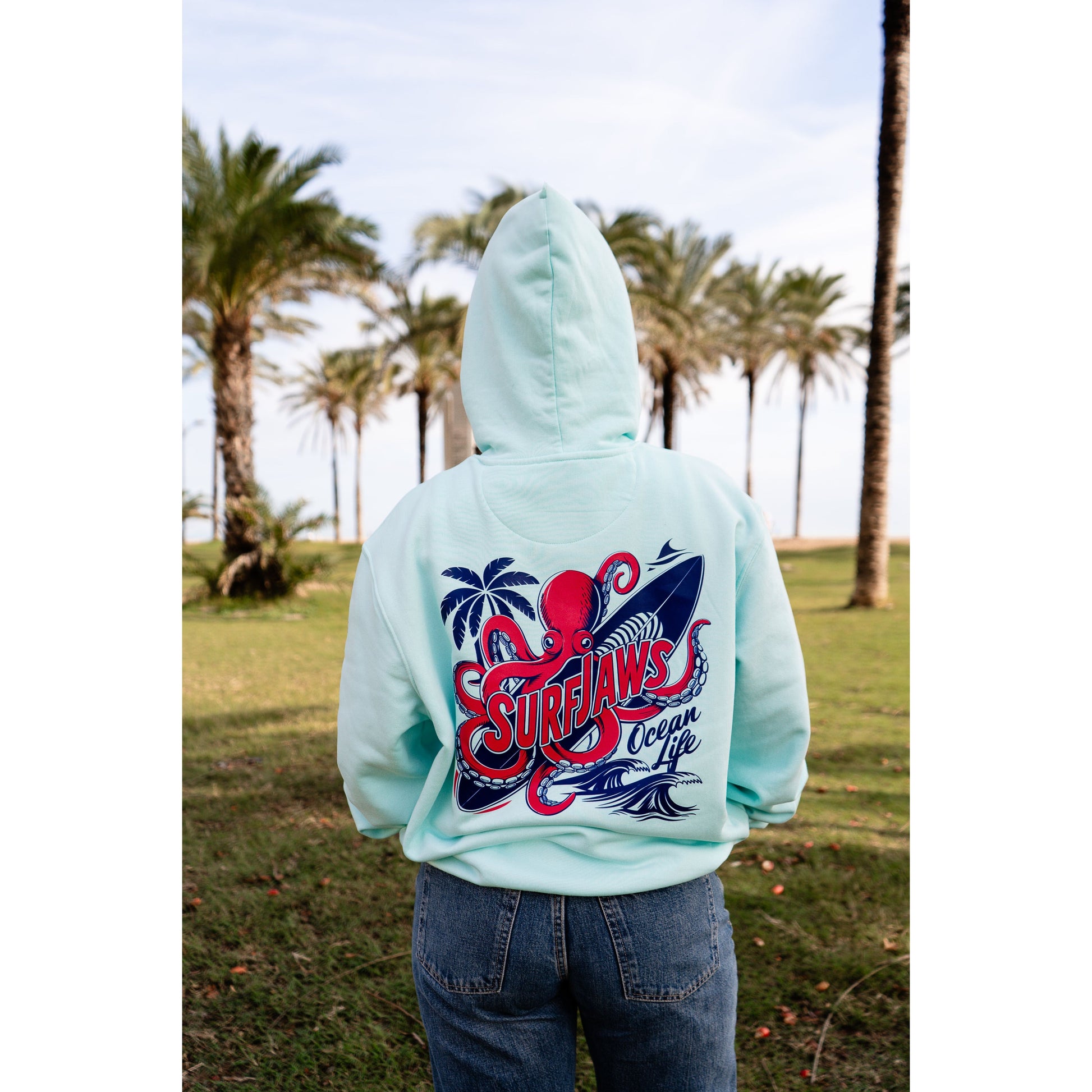 Sudadera SurfJaws de algodón orgánico en tono Ice Mint, ajuste regular. El modelo lleva una talla L, mide 1,56 m y tiene complexión normal, mostrando un estilo cómodo y ecológico