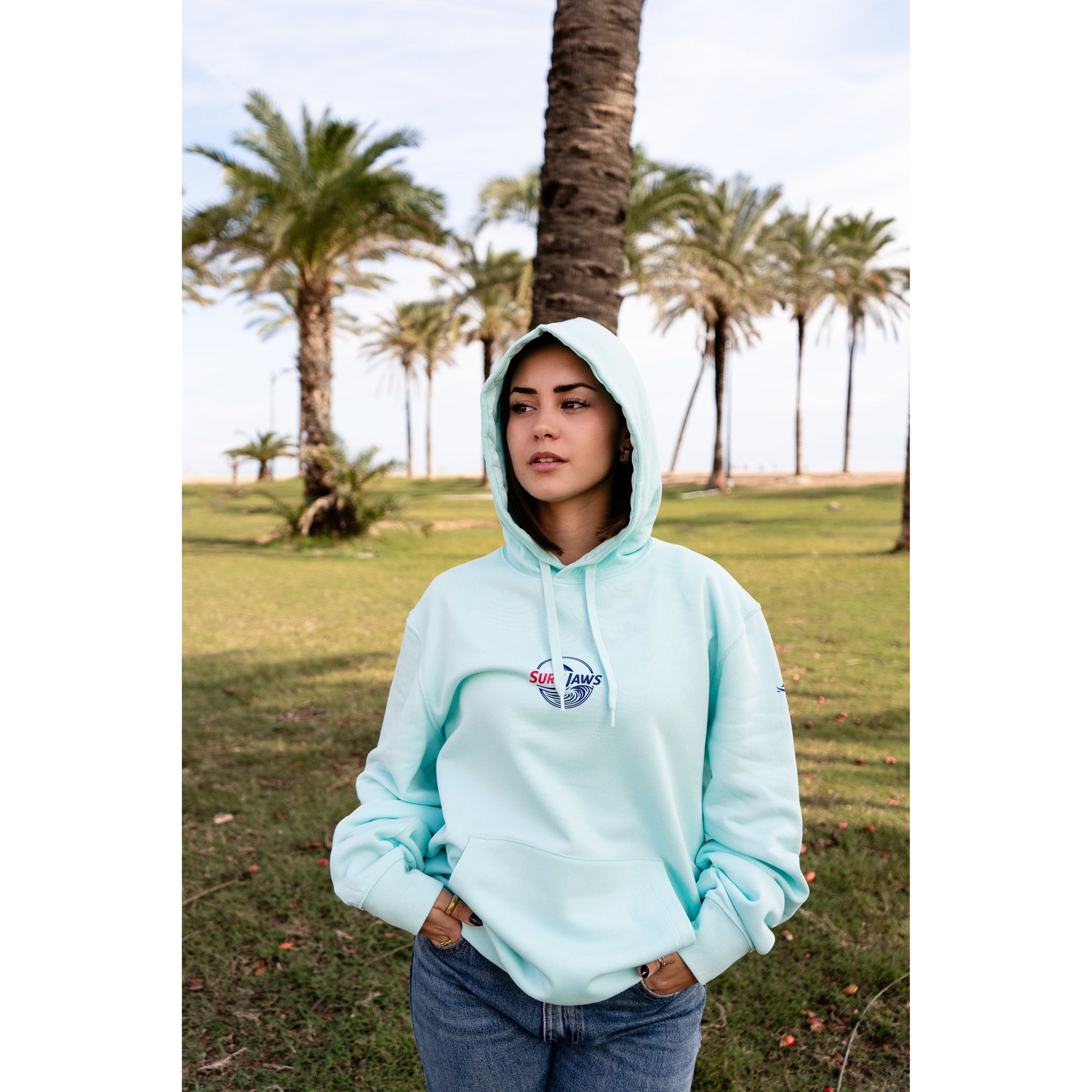 Sudadera SurfJaws de algodón orgánico en tono Ice Mint, ajuste regular. El modelo lleva una talla L, mide 1,56 m y tiene complexión normal, mostrando un estilo cómodo y ecológico