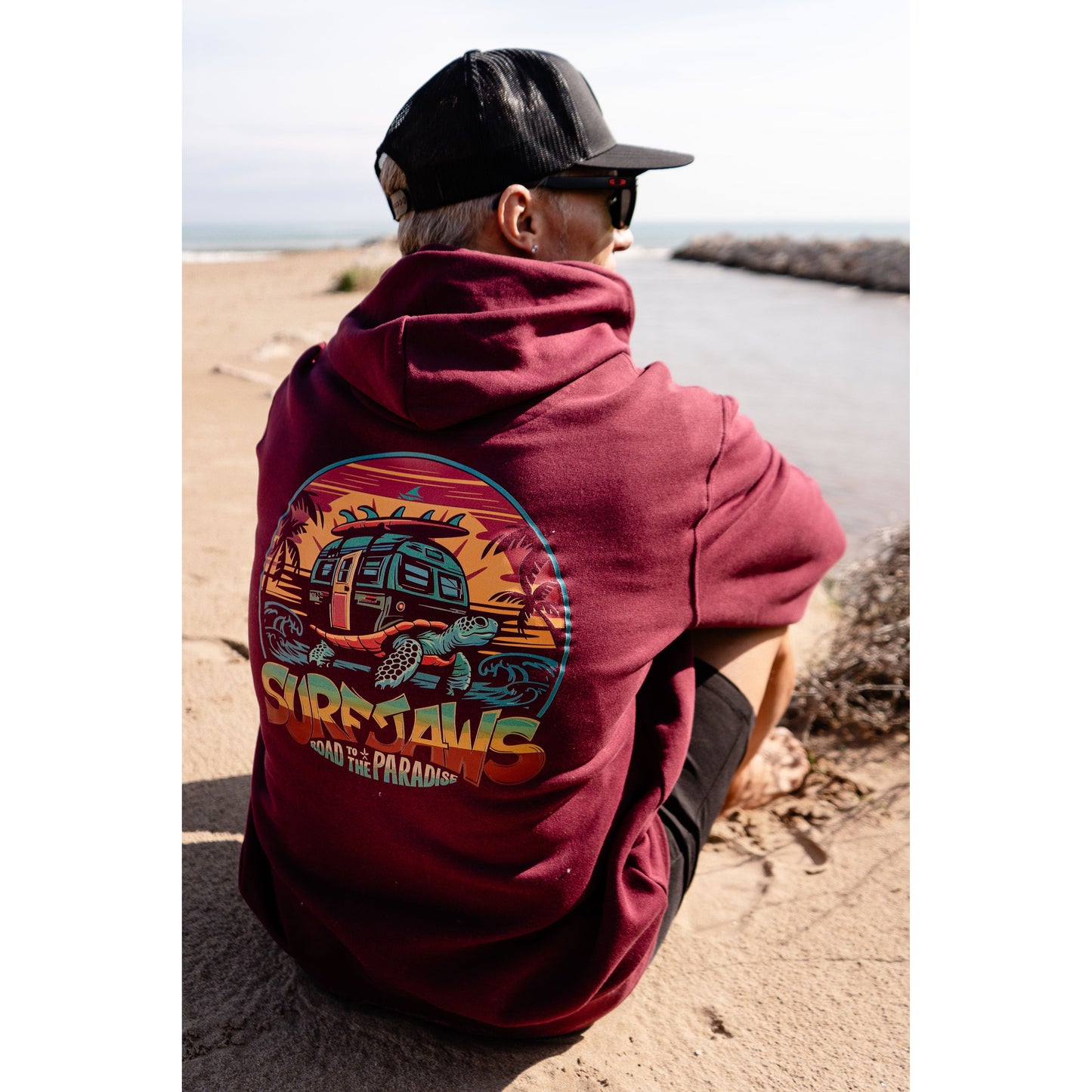 Sudadera SurfJaws de algodón orgánico en tono wine, ajuste regular. El modelo lleva una talla L, mide 1,62 m y tiene complexión atlética, mostrando un estilo cómodo y ecológico