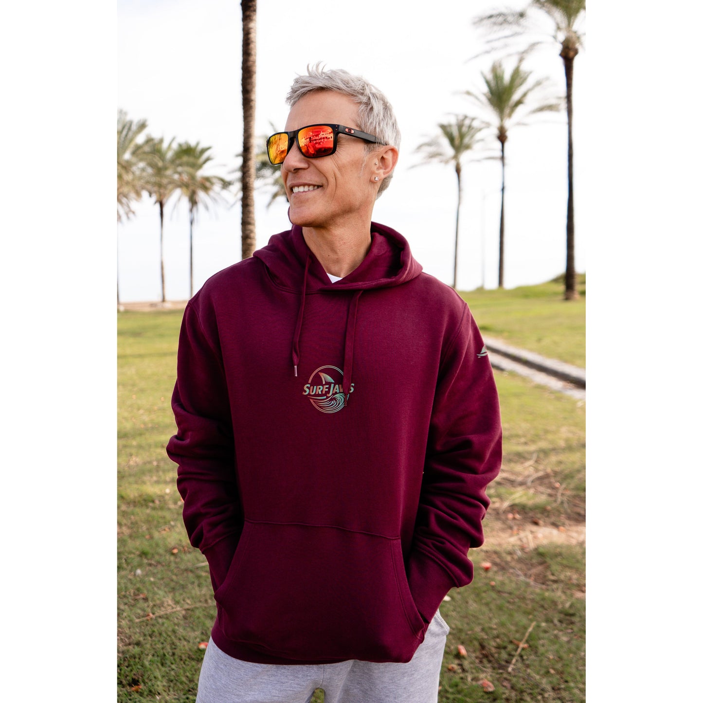 Sudadera SurfJaws de algodón orgánico en tono wine, ajuste regular. El modelo lleva una talla L, mide 1,62 m y tiene complexión atlética, mostrando un estilo cómodo y ecológico