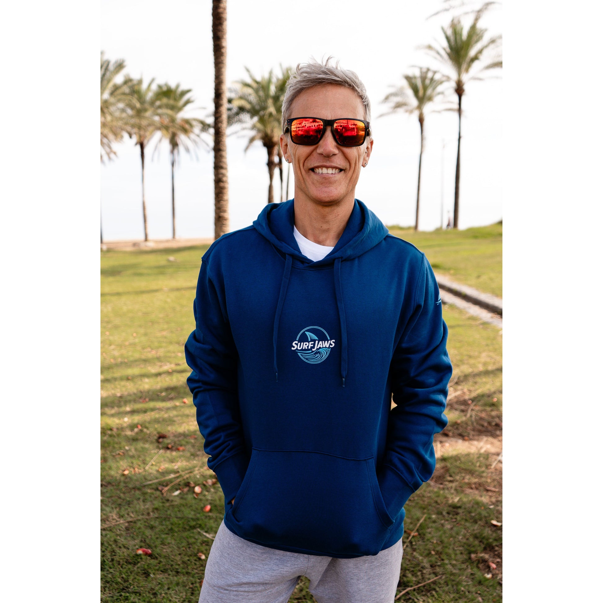 Sudadera SurfJaws de algodón orgánico en tono azul marino ajuste regular. El modelo lleva una talla L, mide 1,62 m y tiene complexión atlética, mostrando un estilo cómodo y ecológico