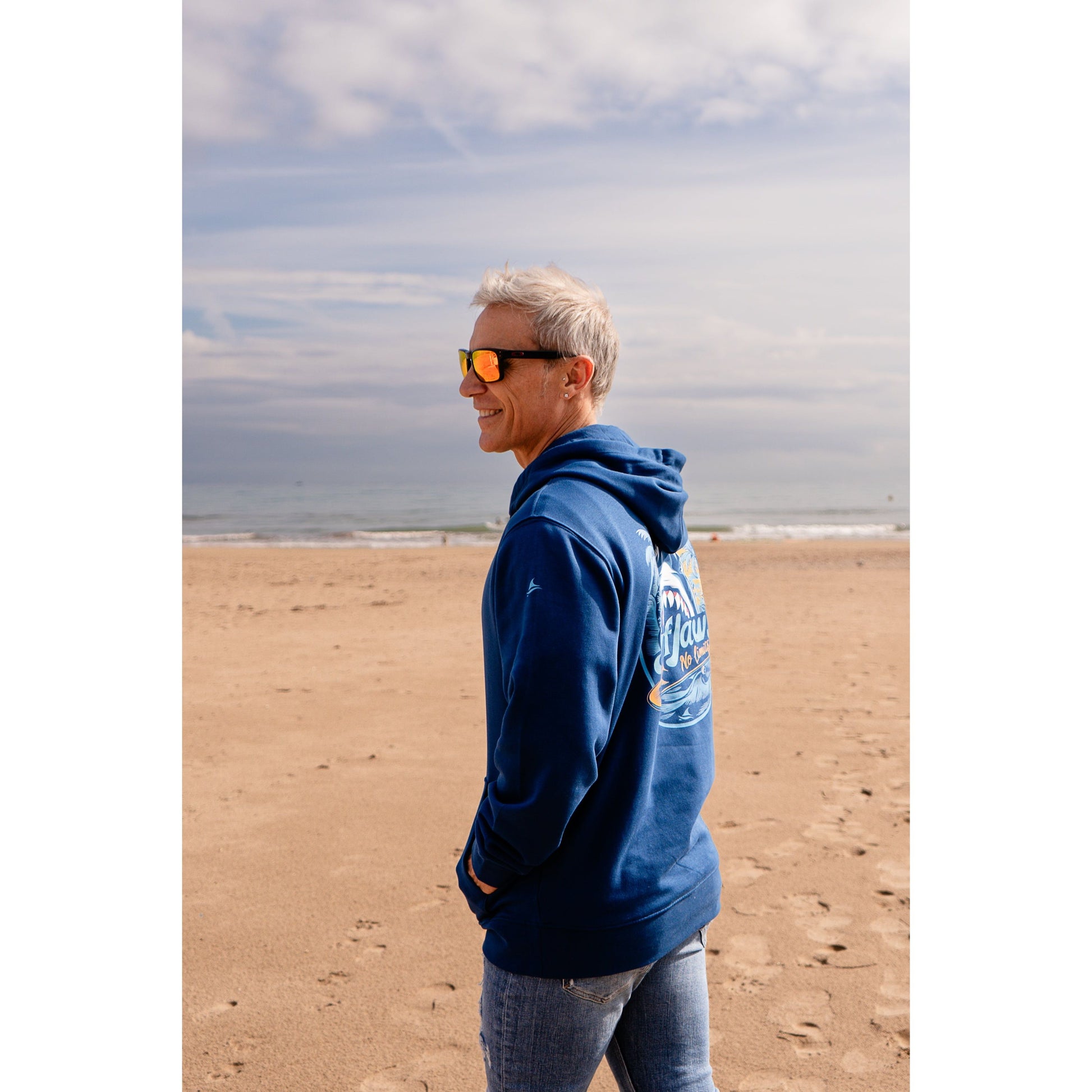 Sudadera SurfJaws de algodón orgánico en tono azul marino ajuste regular. El modelo lleva una talla L, mide 1,62 m y tiene complexión atlética, mostrando un estilo cómodo y ecológico