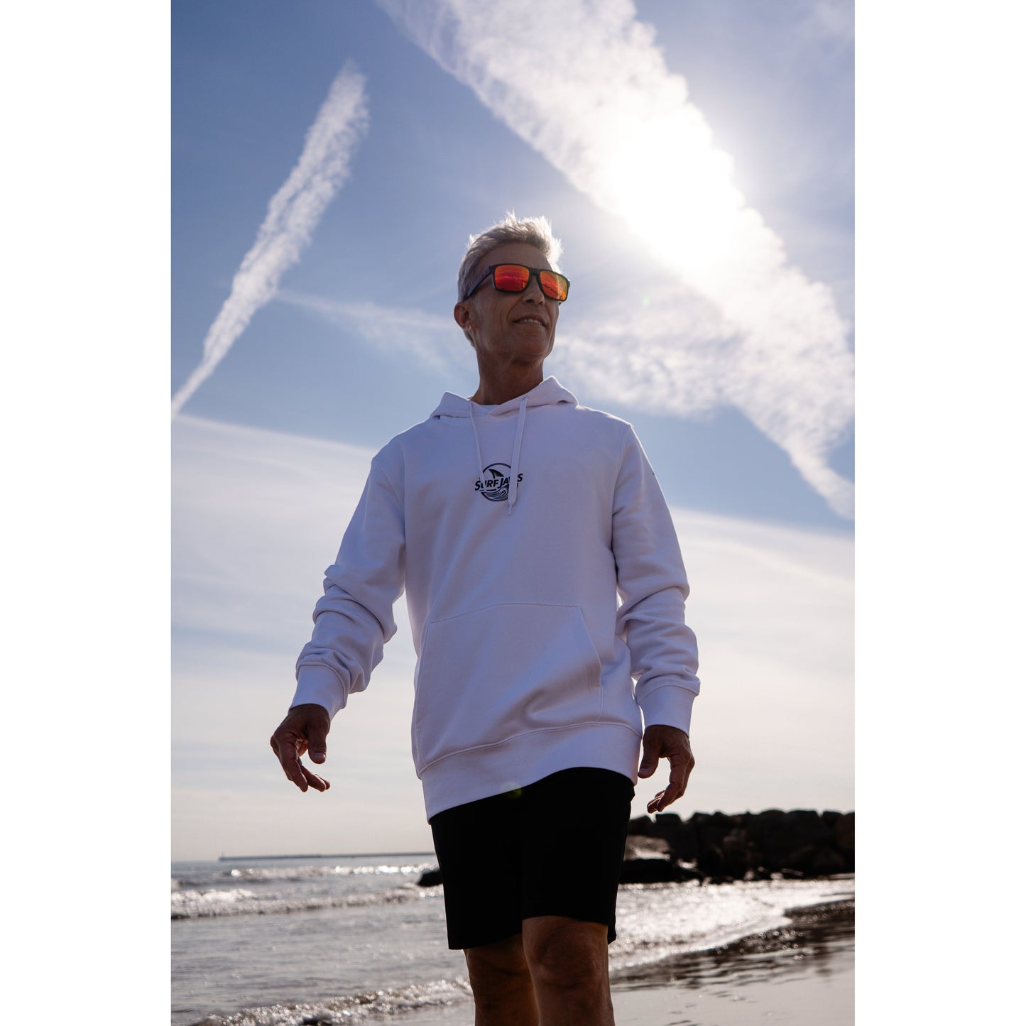 Sudadera SurfJaws de algodón orgánico en tono blanco marino ajuste regular. El modelo lleva una talla L, mide 1,62 m y tiene complexión atlética, mostrando un estilo cómodo y ecológico